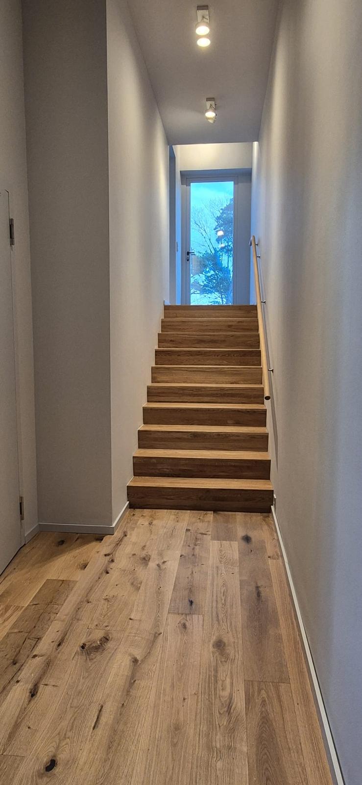 Treppenaufgang mit Holzstufen und hellem Flur