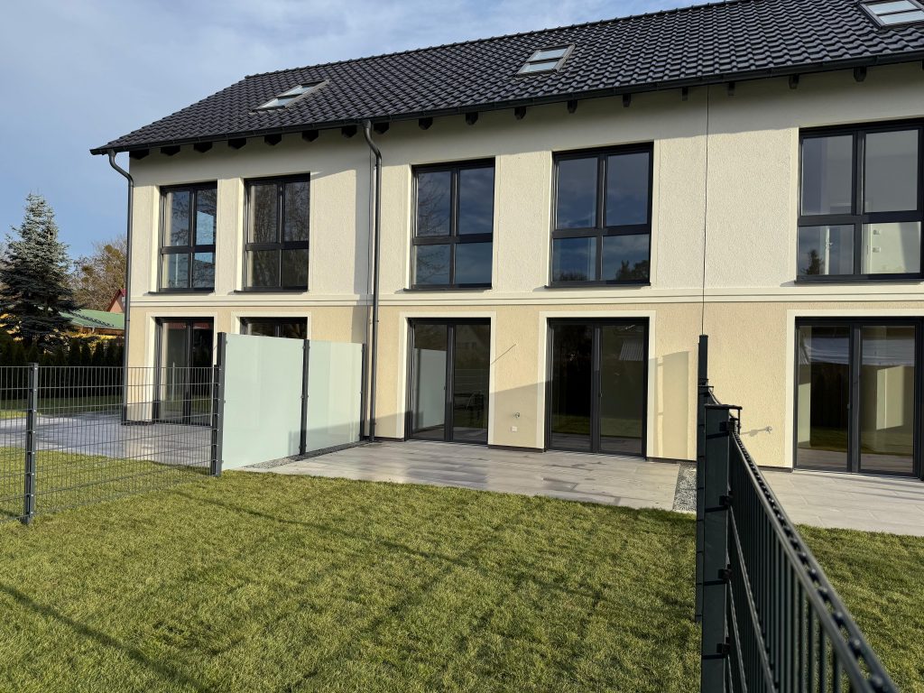 Terrassenseite eines Wohnhauses mit bodentiefen Fenstern