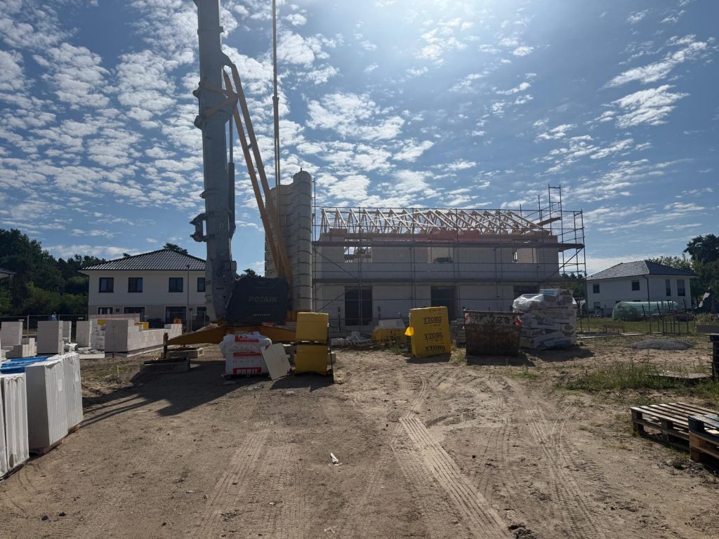 Baustelle mit Betonpumpe und Rohbau