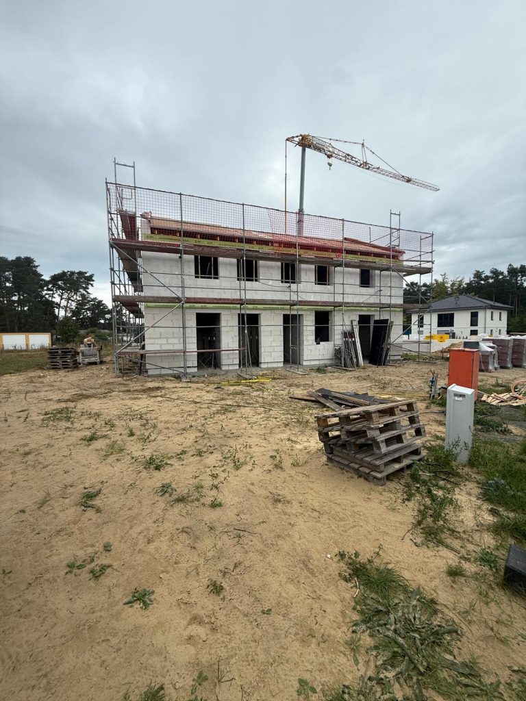 Rohbau mit Gerüst und Baumaterial