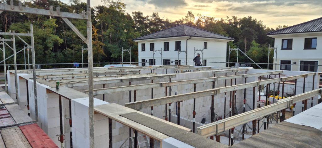 Mauerwerksrohbau mit Schalung vor einem Wohngebiet